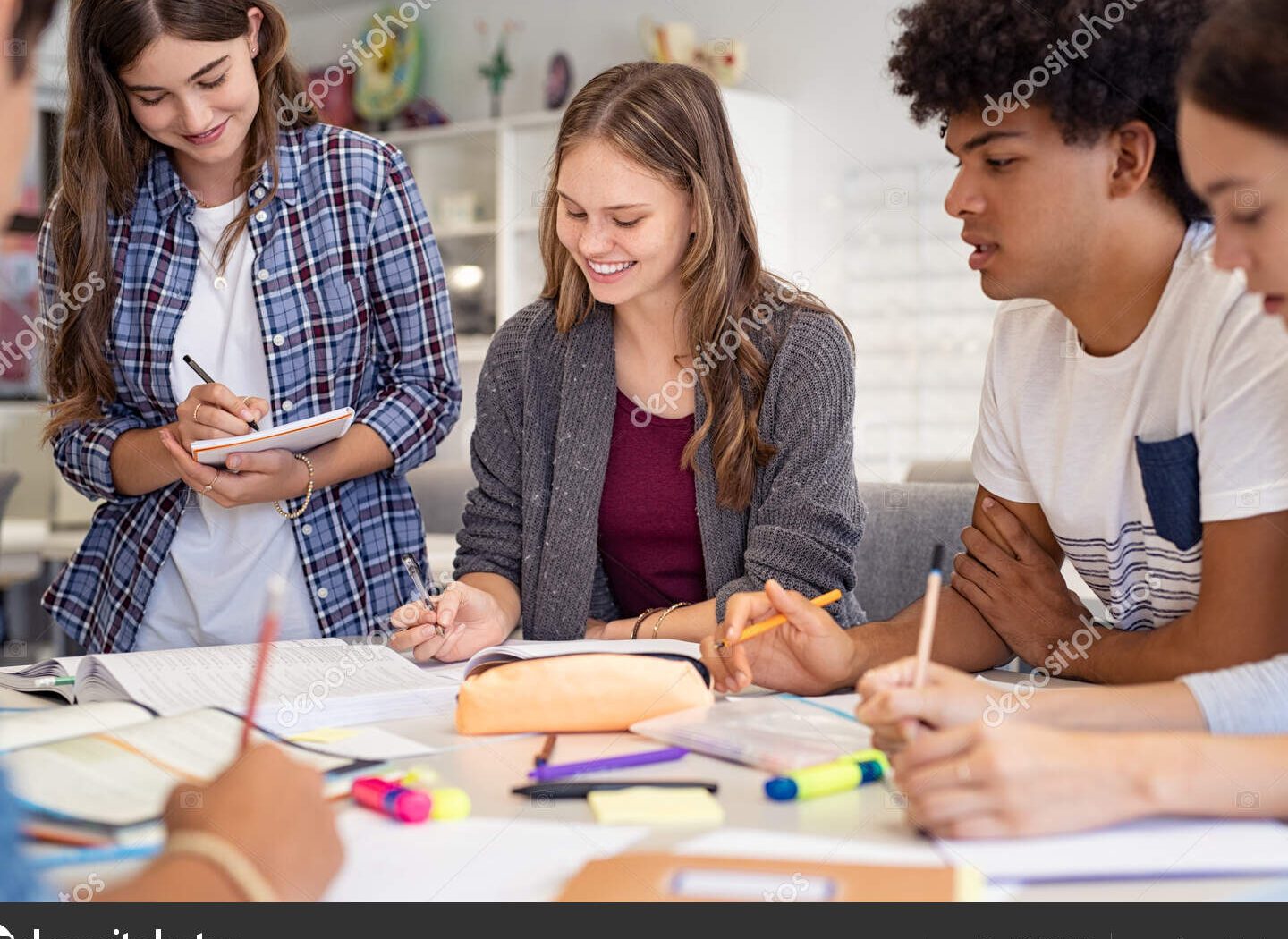 un grupo de estudiantes sonrientes trabajando juntos en un aula