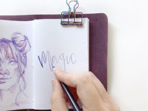 una imagen de un artista dibujando con lapices de colores en un cuaderno